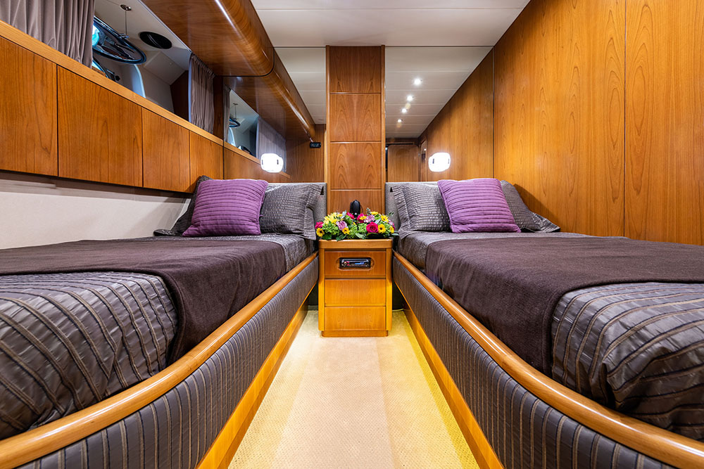 Spacious guest cabin with luxurious bedding and wood-paneled interior, part of the Star Link Falcon 90 yacht charter experien